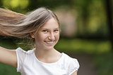 young girl holding hair and smiling