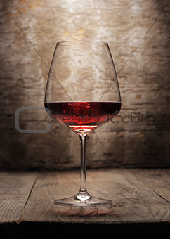 Red wine glass on wooden background