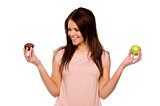 Brunette woman holding up an apple and cake