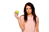 Brunette woman holding up an apple upset
