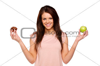 Brunette woman holding up an apple and cake