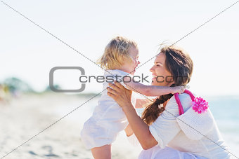 Mother and baby playing on sea shore