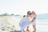 Portrait of happy mother and baby in sunglasses on beach