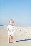 Happy baby running on beach