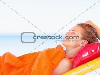 Happy young woman relaxing on sunbed