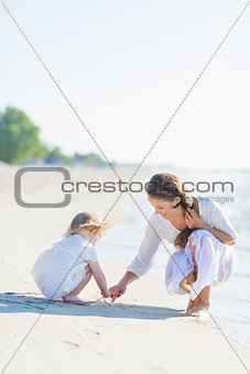 Mother and baby playing on beach