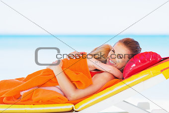 Happy mother and baby laying on chaise-longue