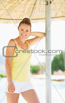 Smiling young woman under umbrella