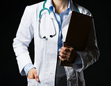 Closeup on doctor woman with clipboard isolated on black
