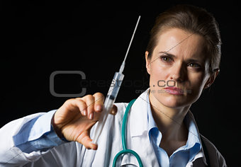 Doctor woman using syringe isolated on black