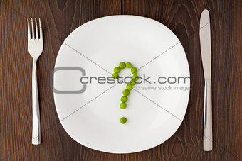 Question mark made of peas on plate
