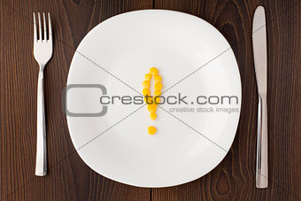 Exclamation mark made of corn seeds on a plate