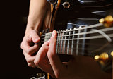 guitarist hands playing guitar over black