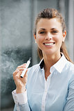 portrait of young woman smoking electronic cigarette outdoor off