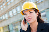 Young Female Contractor Wearing Hard Hat on Site Using Phone