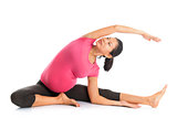 Pregnant woman yoga position seated side stretch.