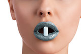 woman with pill between lips 