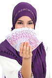Beautiful islamic woman wearing a hijab showing a lot of banknotes