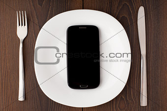 Mobile phone on a white plate