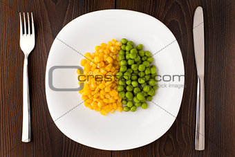 Heap of corn seeds and peas on plate