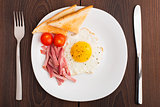 Fried egg with toasts, ham and cherry tomato
