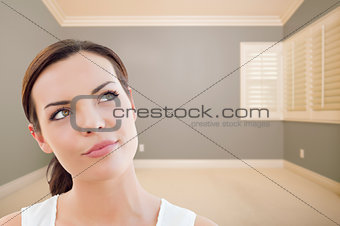 Daydreaming Young Woman in Empty Grey Room