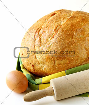large loaf of homemade bread with a kitchen towel