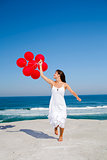 Beautiful girl running with red ballons