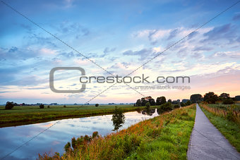road for bicycles and river at sunrise
