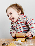 happy young child with rolling pin in grey background