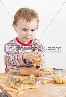 young child with dough in grey background