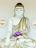 Buddha image statue with fresh flowers in hands