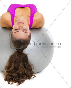 Young woman laying on fitness ball