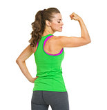 Portrait of female athlete showing biceps