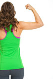 Female athlete showing biceps. rear view
