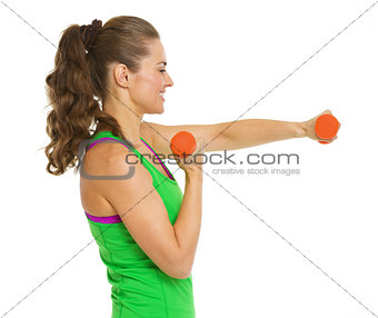 Happy fitness young woman making exercise with dumbbells