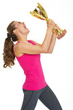 Happy fitness young woman holding gold trophy cup