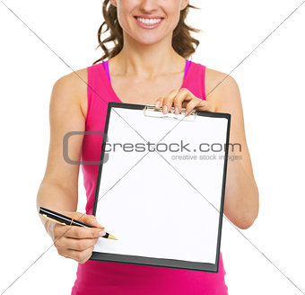 Closeup on fitness trainer giving clipboard for sign