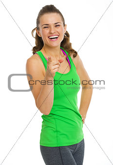 Smiling fitness young woman pointing in camera