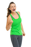 Happy fitness young woman making fist pump gesture