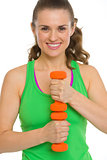 Portrait of happy fitness young woman with dumbbells