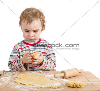 young child with rolling pin and dough