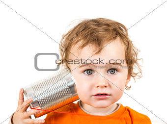 child with tin can phone looking to camera