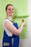 Young woman painting a wall