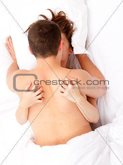 Couple in bed caressing each other