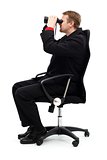 Man sitting in chair and searching with binoculars
