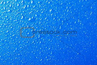 Blue background texture covered with water drops