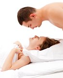 Man looking down on woman laying in bed