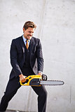 Crazy businessman with a chainsaw