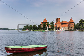 Trakai red brick castle with a boat in front
